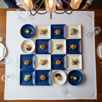 Вид сверху: тарелки синего и молочного оттенков в шахматном порядке