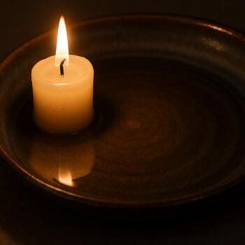 Свеча отражается в матовой глазури тарелки